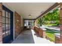 Covered front porch with a swing, brick columns, recessed lighting, and an inviting view of the neighborhood at 5912 Evanston Ave, Indianapolis, IN 46220