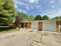 Ranch-style brick home with a two-car garage, front yard landscaping, and a concrete driveway at 6335 Linden Dr, Indianapolis, IN 46227