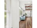 Bright living room featuring hardwood floors, a cozy sofa, and sunlit views through the large window at 6401 N Oakland Ave, Indianapolis, IN 46220