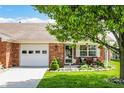 Charming single-story home with a well-manicured lawn, and quaint front porch seating at 8145 Bentley Farms Dr, Indianapolis, IN 46259