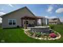 Landscaped backyard features a pergola over a stone fire pit and patio perfect for outdoor relaxation at 934 Steel Horse Dr, Westfield, IN 46074