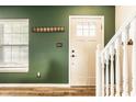 Welcoming entryway features stylish wood flooring, a coat rack, and a staircase at 941 Pine Ridge Way, Brownsburg, IN 46112
