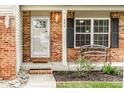 Inviting front porch with brick accents, a decorative bench, and well-maintained landscaping at 941 Pine Ridge Way, Brownsburg, IN 46112