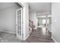 Inviting hallway with hardwood floors, complemented by a charming stairway and a glass-paneled office door at 991 Terra Ln, Franklin, IN 46131
