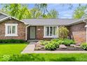Beautiful brick home featuring a charming front garden and lush green lawn at 10444 Collingswood Ln, Fishers, IN 46037