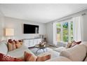 Comfortable living room with a sectional sofa, large window, and modern decor at 10444 Collingswood Ln, Fishers, IN 46037