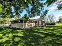 Home exterior surrounded by lush green lawn, mature trees, and partial driveway view at 10751 N Kitchen Rd, Mooresville, IN 46158