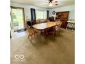 Cozy dining area with a wooden table set, carpet flooring, and vintage-style décor at 10946 Maze Rd, Indianapolis, IN 46259