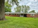 Brick ranch style home sitting on a large green lawn with mature trees at 10946 Maze Rd, Indianapolis, IN 46259