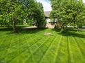 Serene backyard view with neatly striped lawn and mature trees creating a private oasis at 11021 Brentwood Ave, Zionsville, IN 46077
