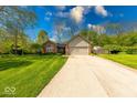 Beautiful home showcasing manicured lawn, mature trees, and a long driveway leading to an attached garage at 1120 Crystal Ct, Avon, IN 46123