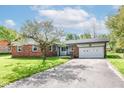 Charming brick ranch-style home with attached garage and mature landscaping at 11603 Peacock Dr, Indianapolis, IN 46236