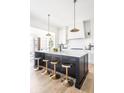 Spacious kitchen island with seating, pendant lighting, and modern design elements at 11904 Spring Mill Rd, Carmel, IN 46032