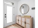 Stylish entryway featuring a modern wooden console, round mirror and an outside view at 127 Monon Green Blvd, Carmel, IN 46032