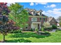 Elegant brick home with lush landscaping, and well-maintained lawn at 13827 Driftwood Dr, Carmel, IN 46033