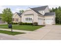 Elegant home featuring a stone and brick design, complete with a two-car garage and a well-maintained front yard at 14003 Grannan Ln, Carmel, IN 46074