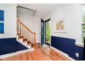 Bright entryway with wood floors, navy blue wainscoting, and staircase at 1409 Alimingo Dr, Indianapolis, IN 46260