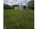 Cozy home with light green siding, red door and an attached shed, on a large grassy lot perfect for outdoor enjoyment at 1503 E 20Th St, Muncie, IN 47302