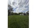 The property features a spacious green lawn and a cozy home with an extension, offering potential for gardening and recreation at 1503 E 20Th St, Muncie, IN 47302