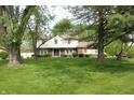 Front view of a two-story home with brick and siding, mature trees, and lush green lawn at 15203 Shoreway Ct, Carmel, IN 46032