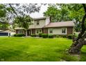 Traditional two-story home features mature trees, manicured lawn and trimmed bushes at 15203 Shoreway Ct, Carmel, IN 46032