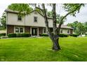 Traditional two-story home with manicured front lawn, trimmed bushes, and mature trees at 15203 Shoreway Ct, Carmel, IN 46032