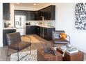 Open concept living area featuring a modern kitchen with black cabinets and stainless steel appliances at 1525 Marlowe Ave, Indianapolis, IN 46201