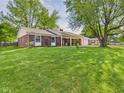 Expansive front lawn of the brick home with mature shade trees at 1813 Kingsley Dr, Anderson, IN 46011