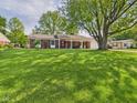 Large front yard of a brick home with mature landscaping and shade trees at 1813 Kingsley Dr, Anderson, IN 46011