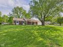 Expansive front lawn of the brick home with mature shade trees at 1813 Kingsley Dr, Anderson, IN 46011