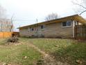 Exterior shot of a home and backyard with a fenced in yard with small pile of wood debris at 2867 S Oakland Dr, Shelbyville, IN 46176