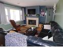 Cozy living room with a fireplace, built-in shelving, large windows, and comfortable leather seating at 2867 S Oakland Dr, Shelbyville, IN 46176