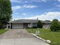 Inviting one-story home featuring a spacious driveway and landscaped front yard at 2927 E 8Th St, Anderson, IN 46012