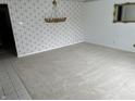 Spacious living room with neutral carpet, elegant chandelier, and decorative wallpaper at 2927 E 8Th St, Anderson, IN 46012