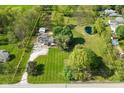 Aerial view of property highlighting house, pond, outbuildings, and surrounding landscape at 296 W Greencastle Rd, Mooresville, IN 46158