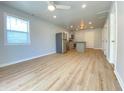 Open-concept living space with light wood flooring, recessed lighting, stainless appliances, and ample natural light at 3411 Chase St, Indianapolis, IN 46217