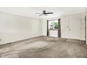 Bright living room with neutral carpet, ceiling fan, a window with natural light, and a white front door at 374 S Baldwin St, Bargersville, IN 46106