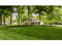 Beautiful home with lush green lawn, mature trees, and attached garage at 411 Woodland W Dr, Greenfield, IN 46140