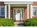 Inviting front entrance with a white door, decorative wreath, and charming landscaping at 4956 Waterside Cir, Carmel, IN 46033
