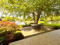 Serene backyard patio with outdoor dining set, overlooking a picturesque pond with fountains and lush landscaping at 5190 Pursel Ln, Carmel, IN 46033
