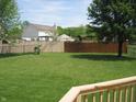 Spacious backyard with lush lawn, a combination wood and chain link fence, and mature trees at 533 Charnwood Pkwy, Beech Grove, IN 46107