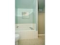Bright bathroom with a tub, a glass-door shower, tiled floors and light green walls at 533 Charnwood Pkwy, Beech Grove, IN 46107