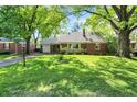 Lovely brick home with a spacious front yard and mature shade trees at 5840 Brouse Ave, Indianapolis, IN 46220