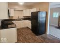 Bright kitchen featuring white cabinets, dark countertops, stainless steel sink, and modern flooring at 706 Alexander St, Greenwood, IN 46143