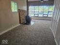 Cozy living room with large windows, wood burning stove, stone accent, and new carpeting at 706 Alexander St, Greenwood, IN 46143