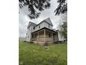 Two-story home with a covered porch, surrounded by a green lawn at 715 S Anderson St, Elwood, IN 46036