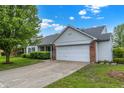 Side view of a home, featuring a brick-accented garage, well-kept lawn, and a concrete driveway at 7156 Chemistry Ct, Indianapolis, IN 46239