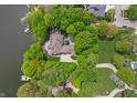 Aerial view of a waterfront brick home, with mature trees, and a well-manicured lawn at 7400 Oakbay Dr, Noblesville, IN 46062