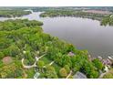 Wide aerial shot showcasing the community, a waterfront property, mature trees, and verdant green lawns at 7400 Oakbay Dr, Noblesville, IN 46062