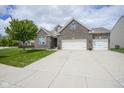 Charming brick home with a wide driveway and green lawn, perfect for Gathering living at 7632 Nestucca Trl, Noblesville, IN 46062